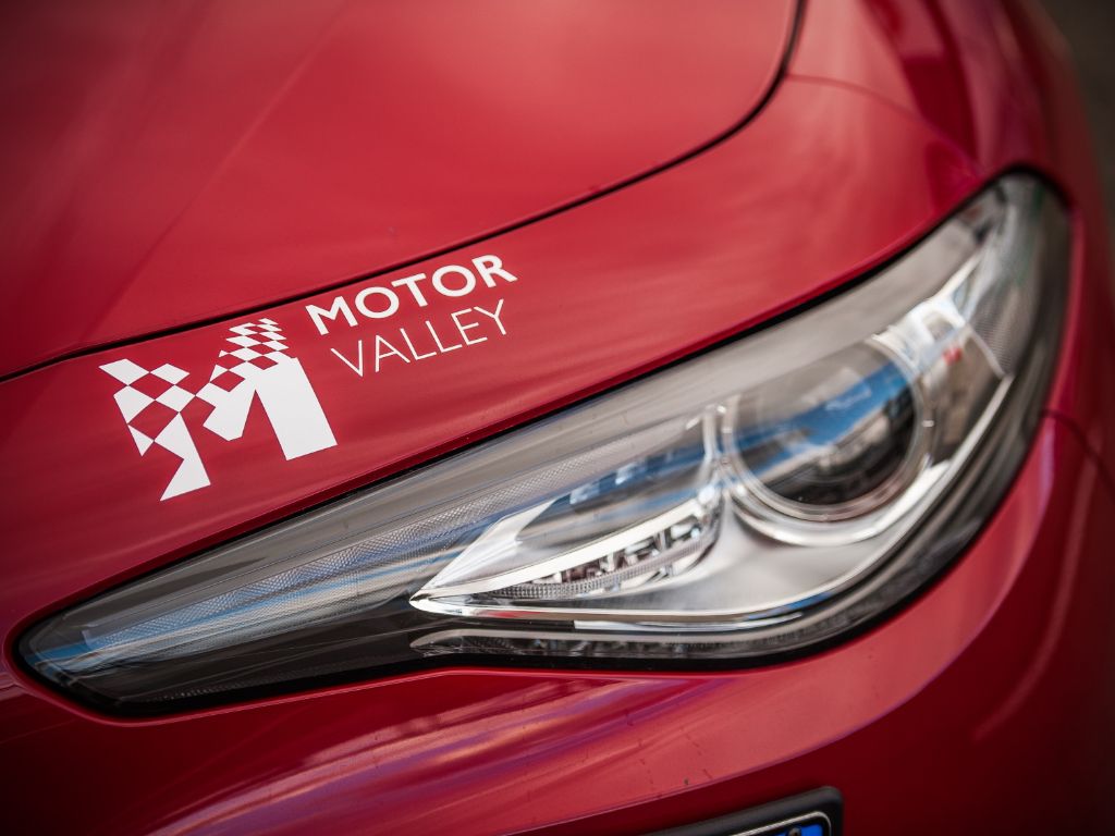 Fanale di un'Alfa Romeo con il logo Motor Valley poco sopra.