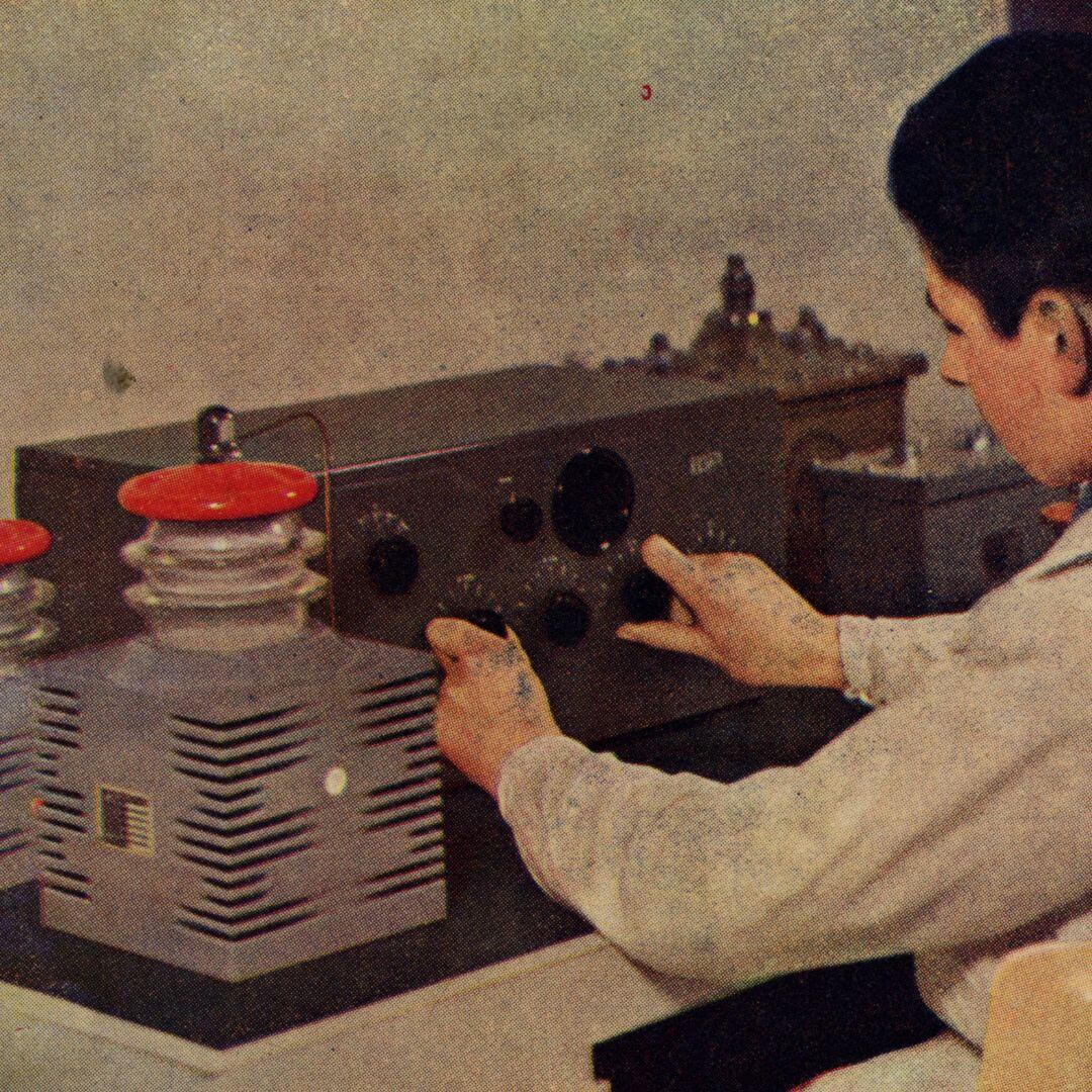 foto d'epoca ricolorata di operatore al collaudo dei condensatori di una radio Ducati