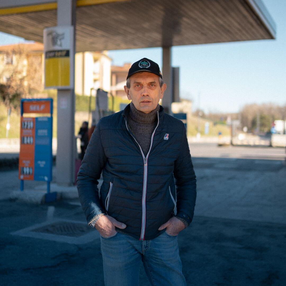 photo of ladies in down jackets and caps standing with a gas pump behind them