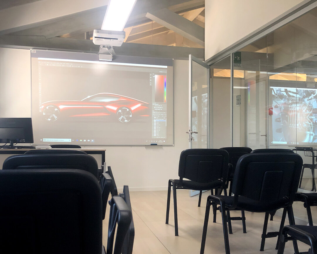classroom interior with chairs for students and a screen showing a render of a car