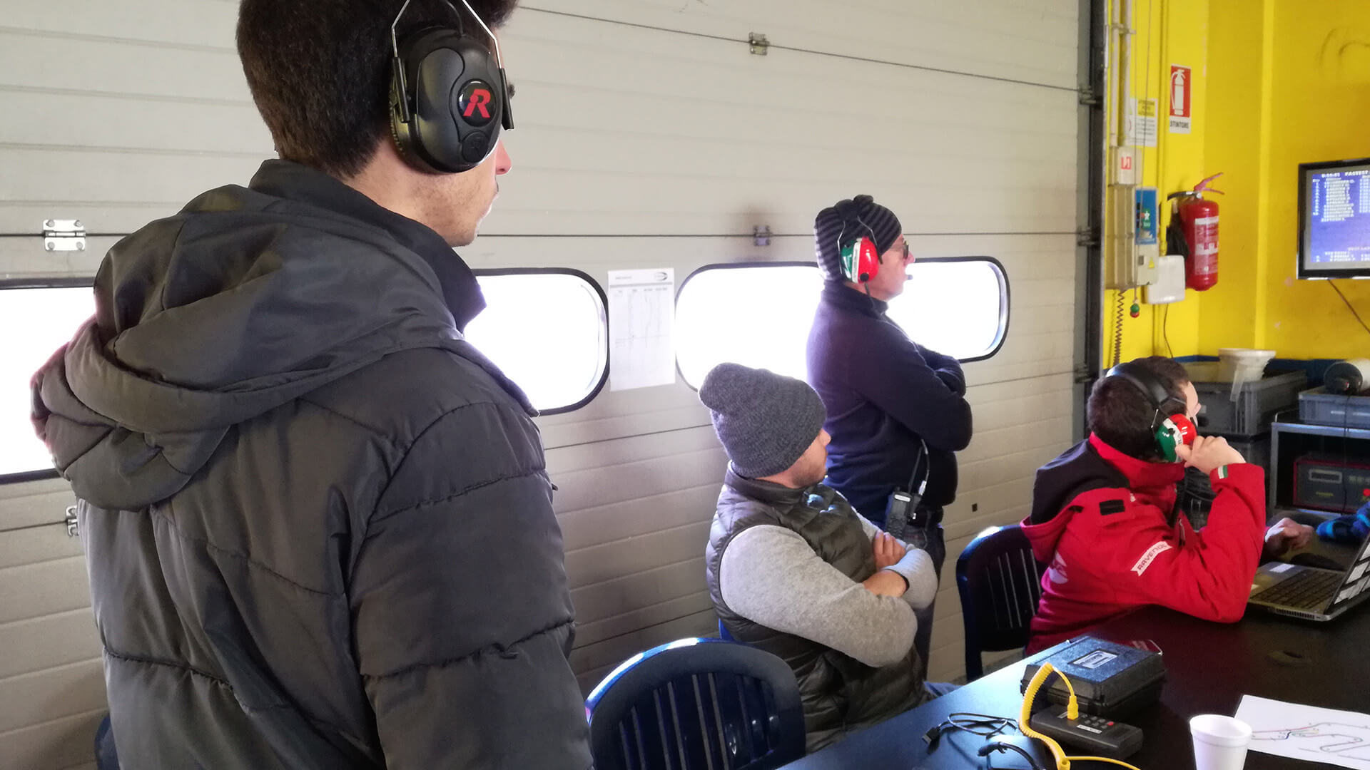 Men with noise-canceling headphones with microphone watching results on overhead screen