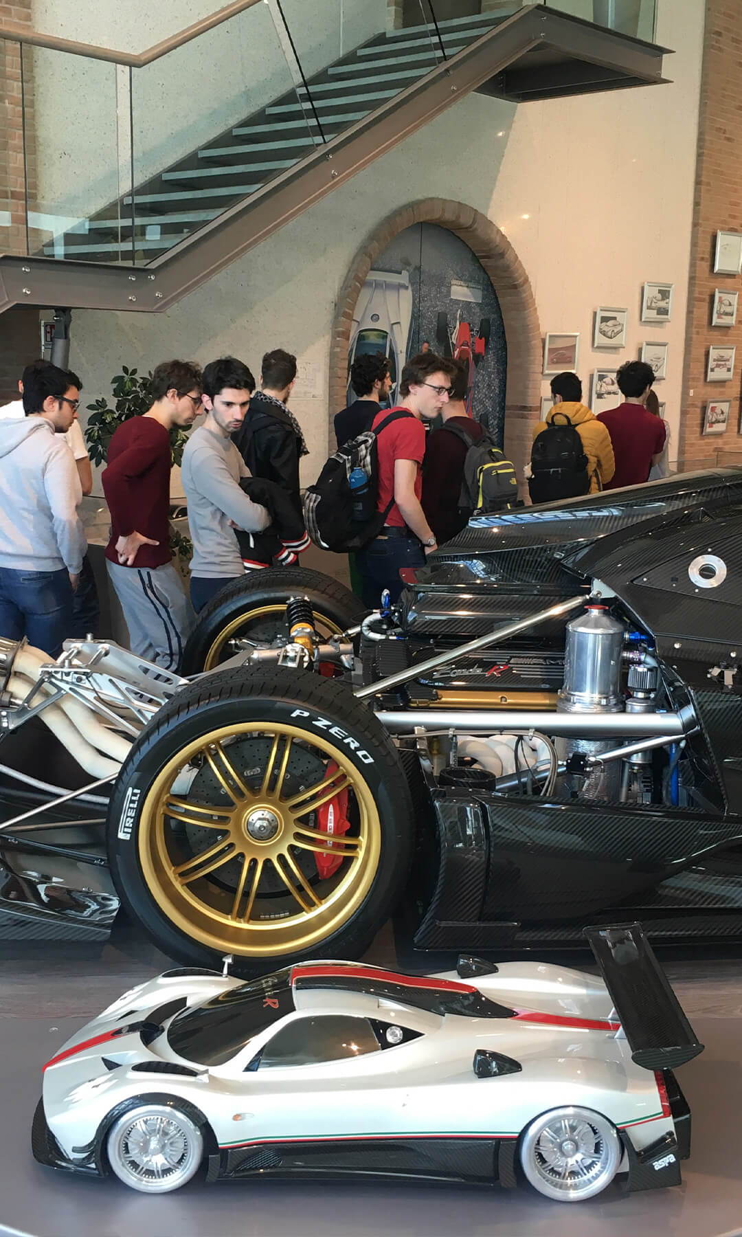 Students visiting the Pagani museum observing a race car