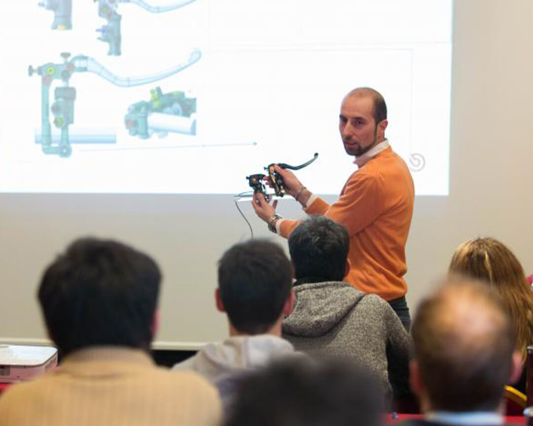 Teacher with brake caliper explaining its operation to students