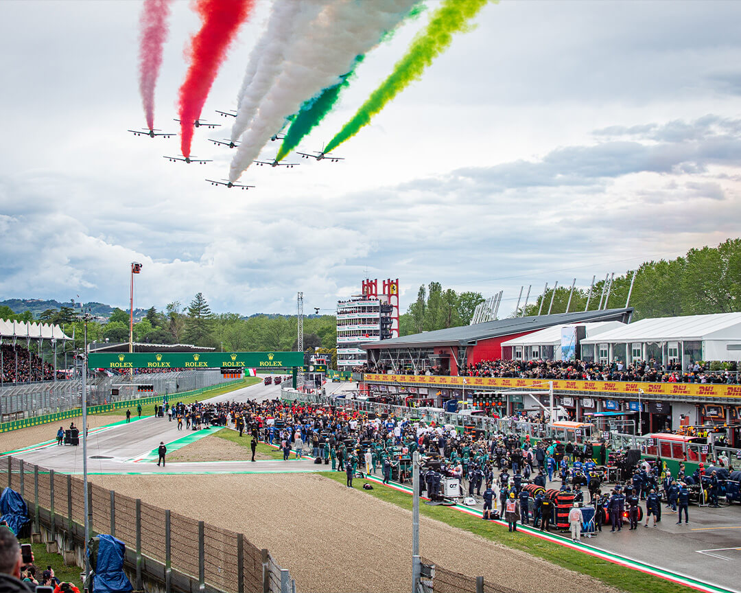 autodromo enzo e dino ferrari che durante un gran premio di formula uno viene sorvolato dalle frecce tricolori in formazione