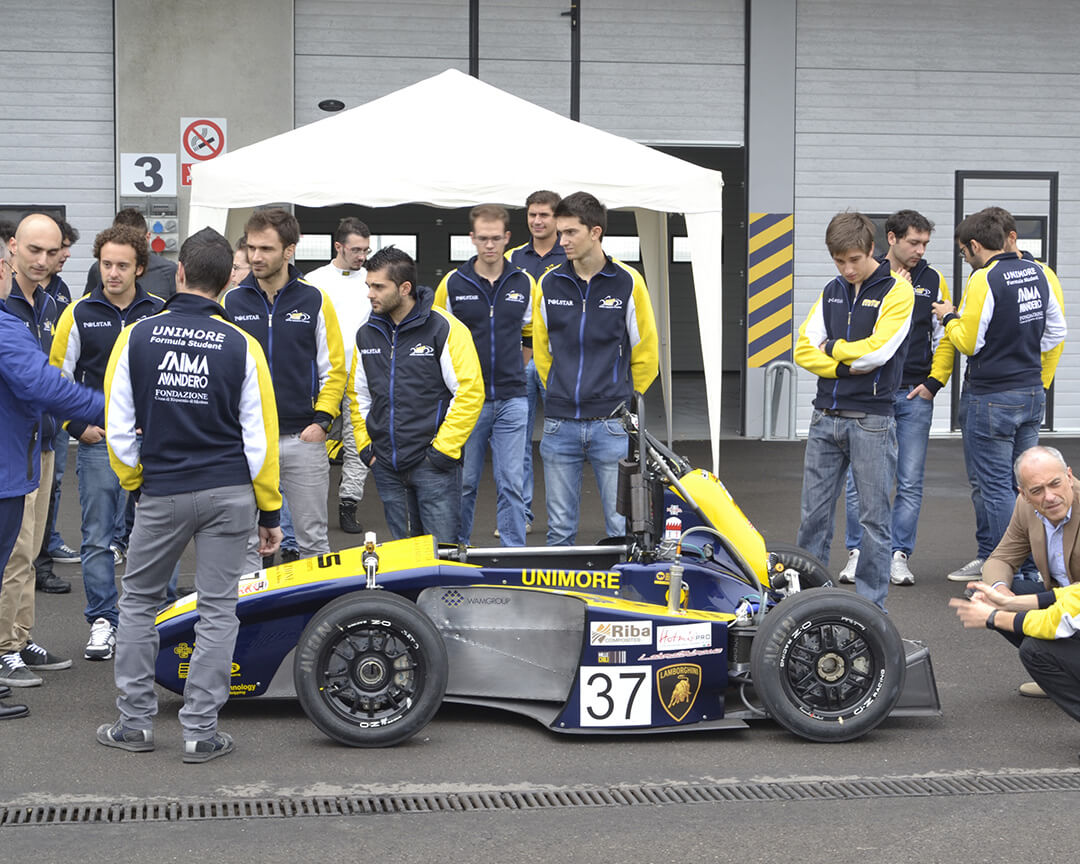 Un team di kart elettrici che osserva la vettura, nel circuito dell'autodromo di modena