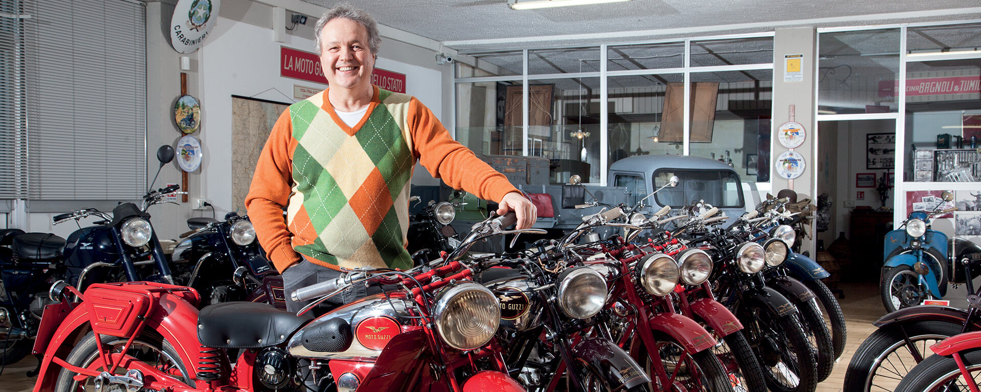 Elio Brunelli smiling with the collection of vintage motorcycles