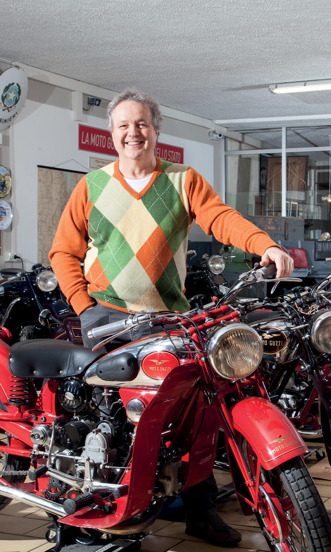 Elio Brunelli smiling with the collection of vintage motorcycles