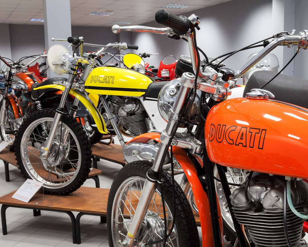 side view of two orange and yellow Ducati vintage motorbikes