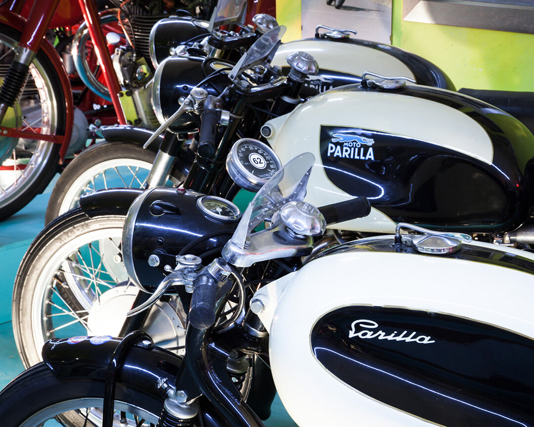 Two modes from the Parilla collection, in black and white coloring, side by side, inside a Parilla showroom