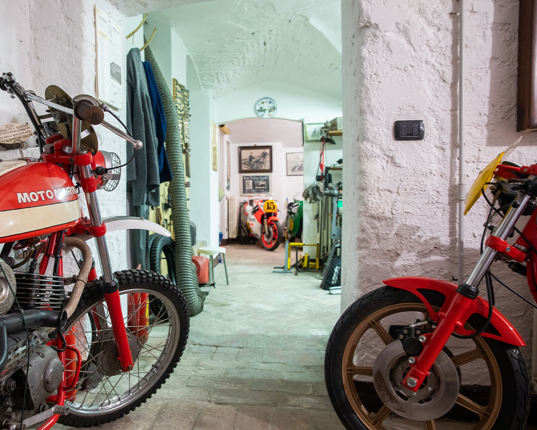 Inside the Parmeggiani Collection workshop, a collectible morini motorcycle in the foreground, among other vintage motorcycles and equipment