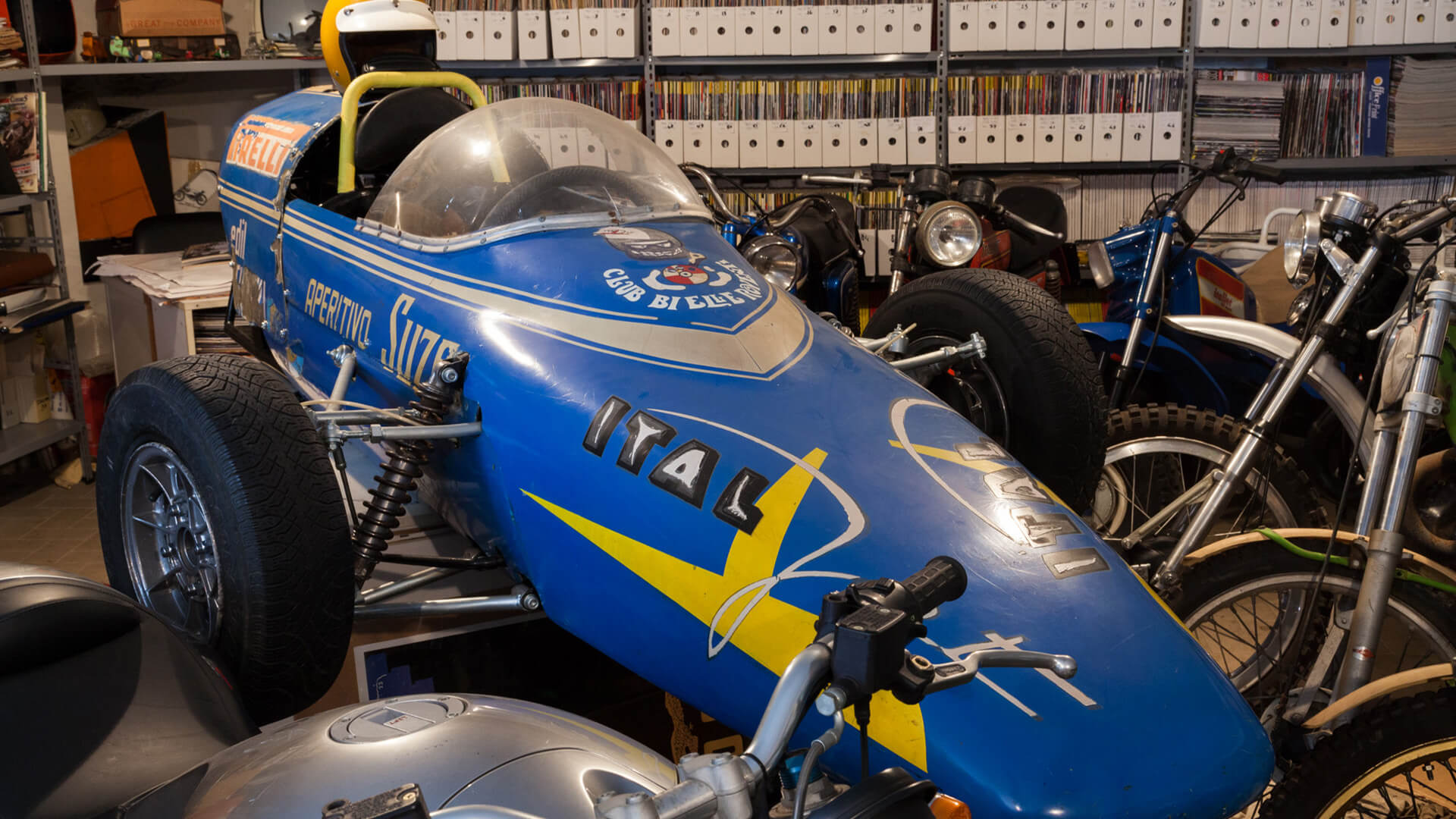 Front part of a vintage single-seater inside an exhibition hall of the pasquale mesto collection, among other vintage motorcycles