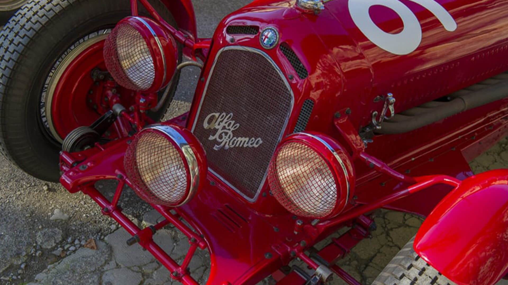 nose of a vintage red alfaromeo, from the righini collection, detailing the alfaromeo lettering and logo