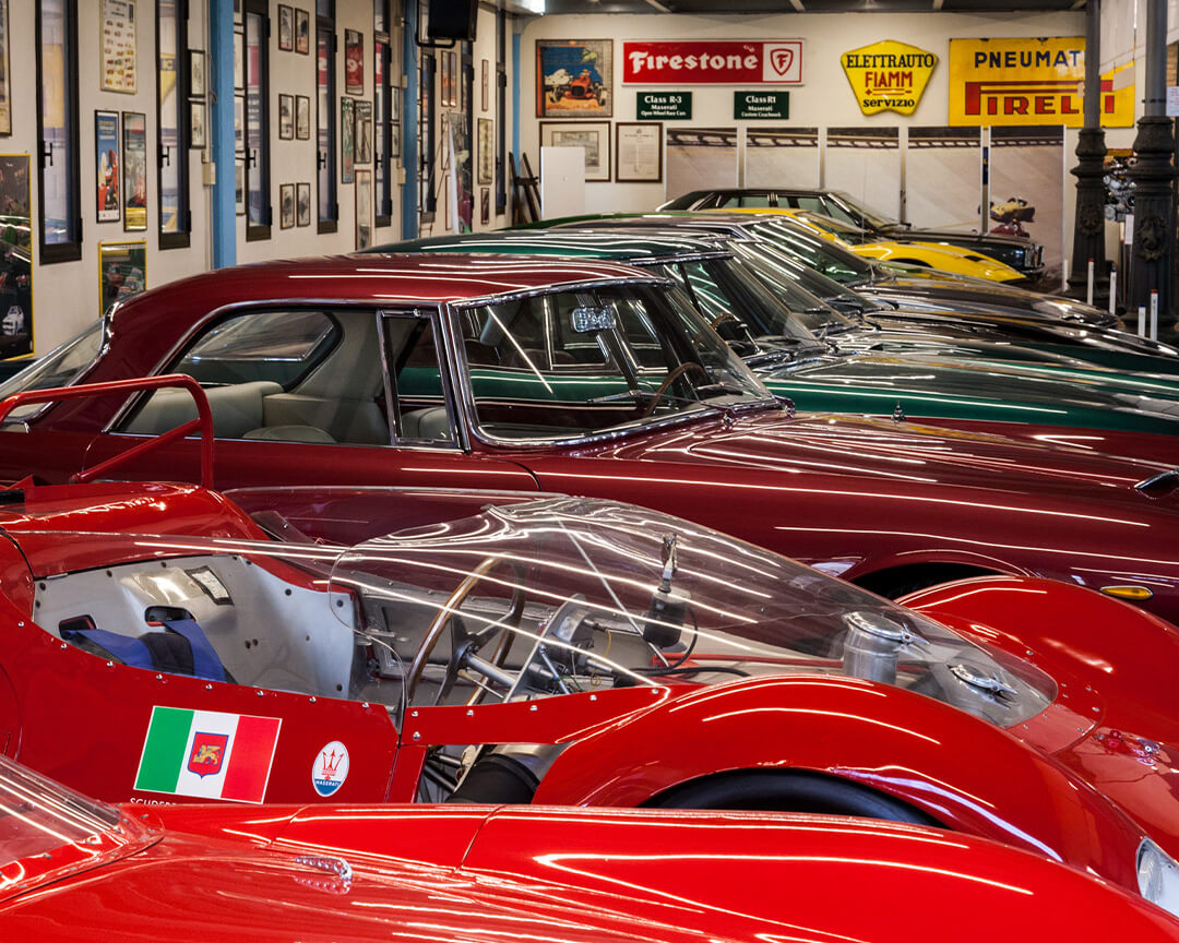 All'interno di una delle sale della collezione Umberto Panini, sono parcheggiate diverse auto da collezione maserati circondate da cimeli e foto