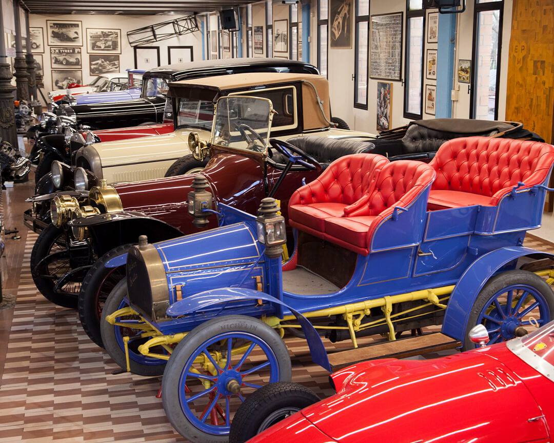 All'interno della collezione umberto panini, si vedono  svariate auto da collezione di diversi colori e con carrozzerie di stile antico, le pareti sono ricoperte di cimeli automobilistici