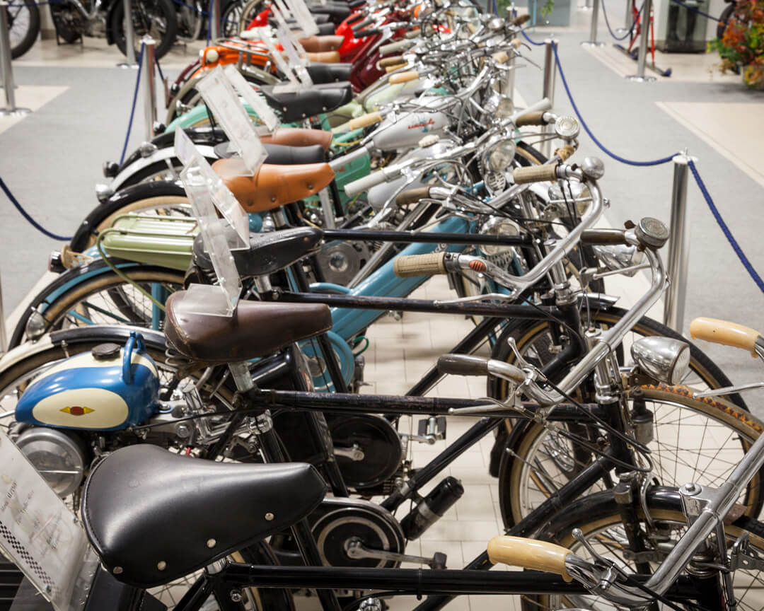 A series of collector's bikes, with the explanatory tag on the saddle, inside the Briaschi motorbike museum