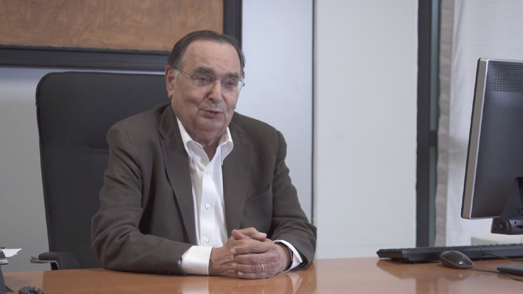 ingegnere Gianpaolo Dallara seduto alla sua scrivania durante un'intervista