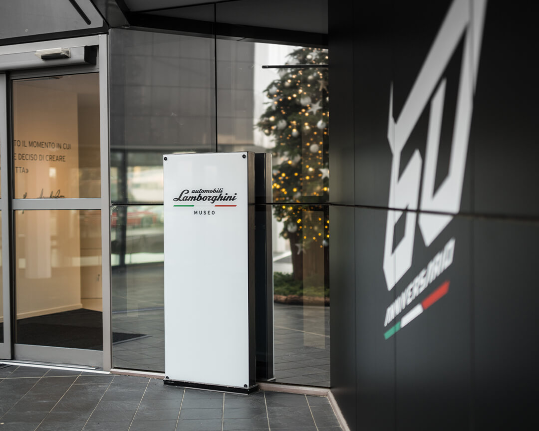 Lamborghini museum entrance with logo sign and blurry 60th anniversary inscription