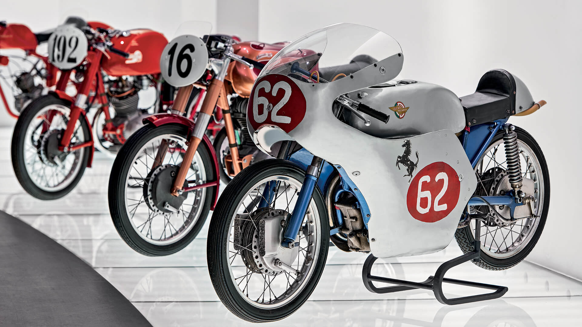 Side view of vintage Ducati Meccanica motorcycle with number 62 and metallic blue details