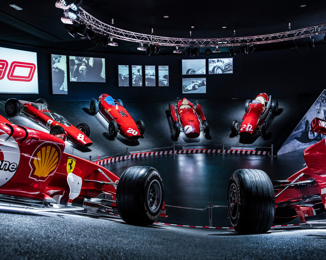 In a room of the ferrari museum in maranello, several historical single-seater models of the ferrari racing stable are displayed on a sloping display platform