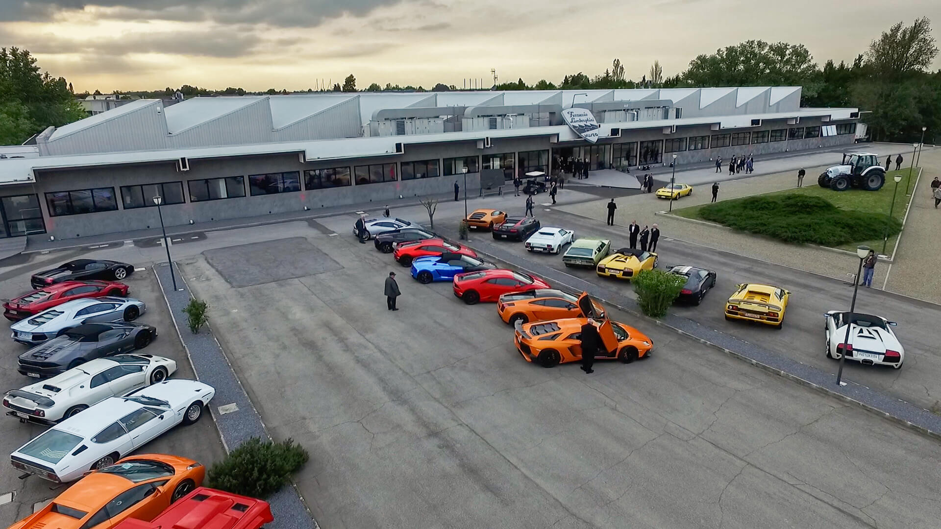 Car park outside the ferruccio lamborghini museum, with several current and vintage lamborghinis parked