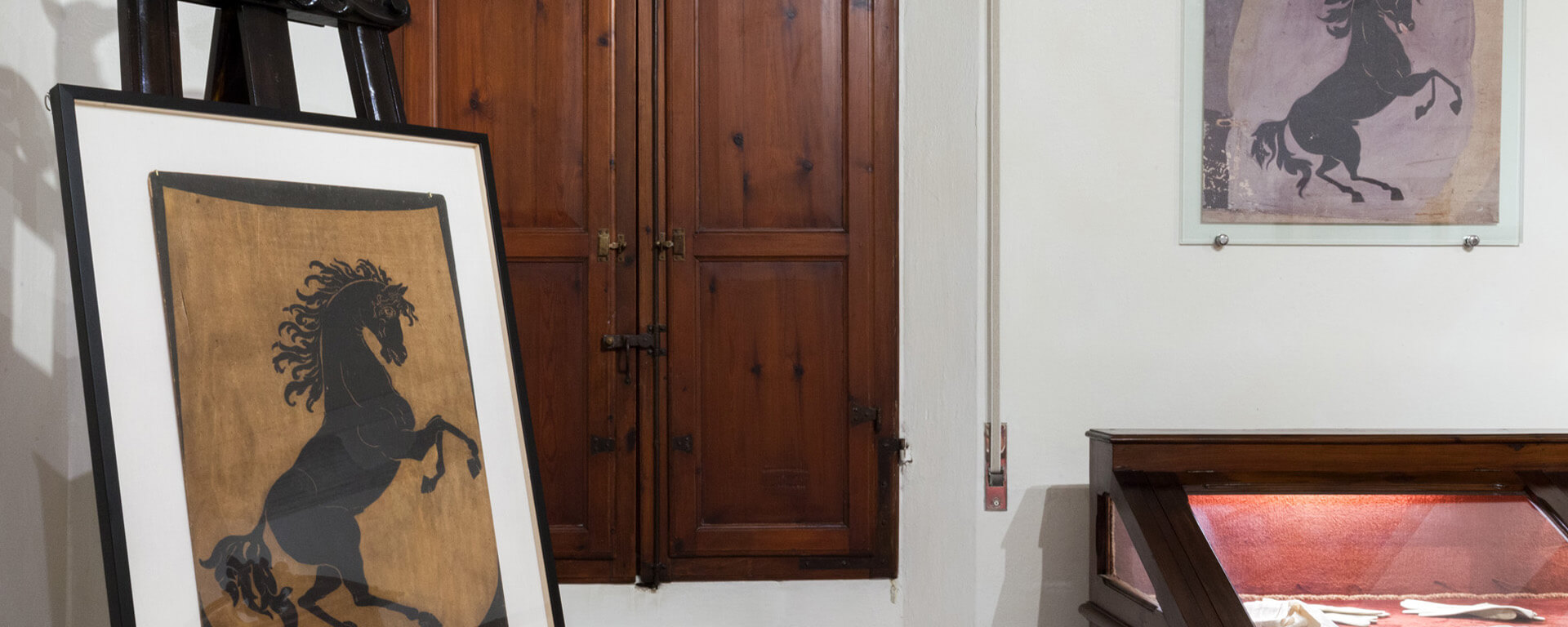 All'interno di una cornice, una tela che raffigura il cavallino rampante simbolo di Francesco Baracca, in una della stanze dell'omonimo museo