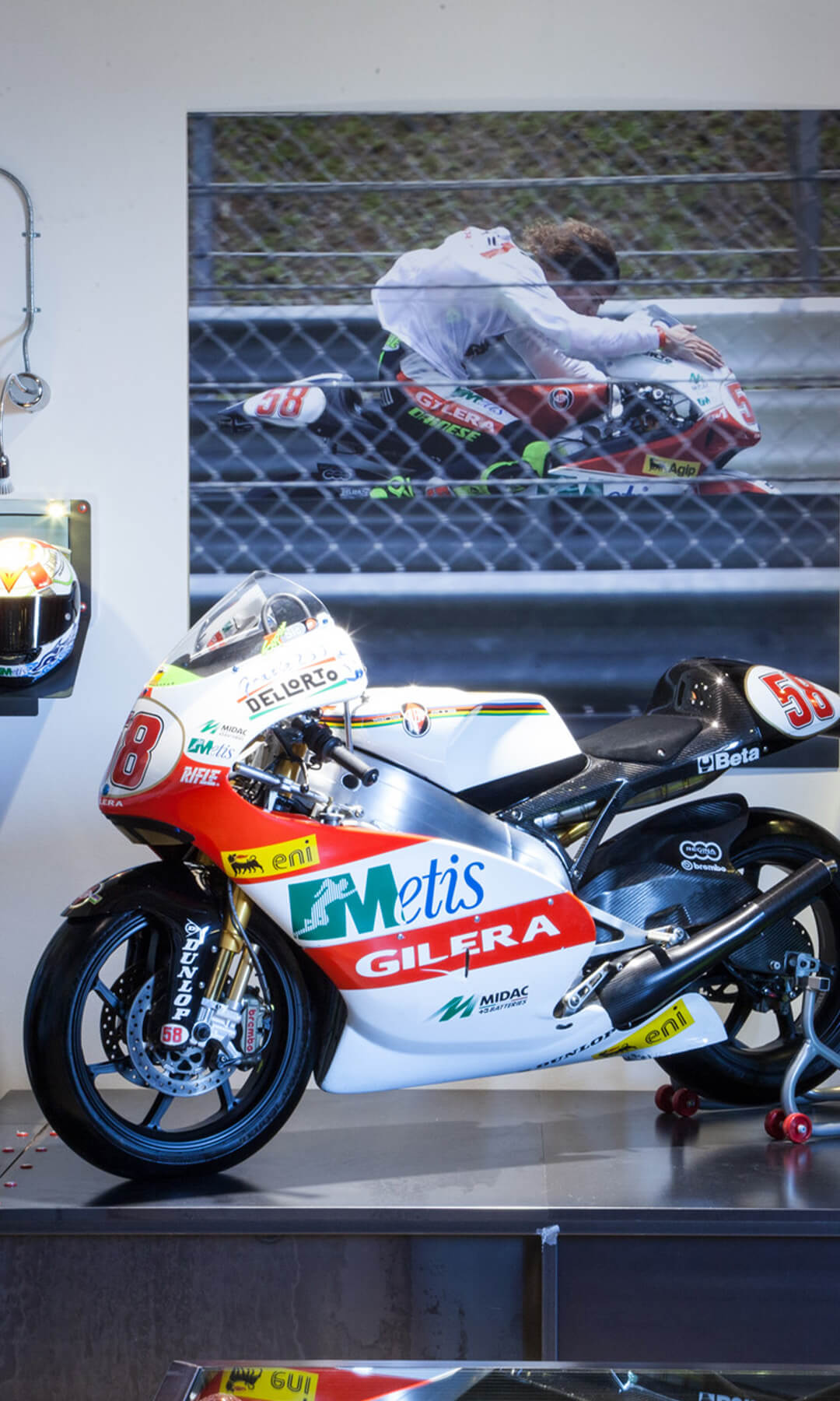 in primo piano moto numero 58, dietro due caschi e tute da corse di moto di Marco Simoncelli