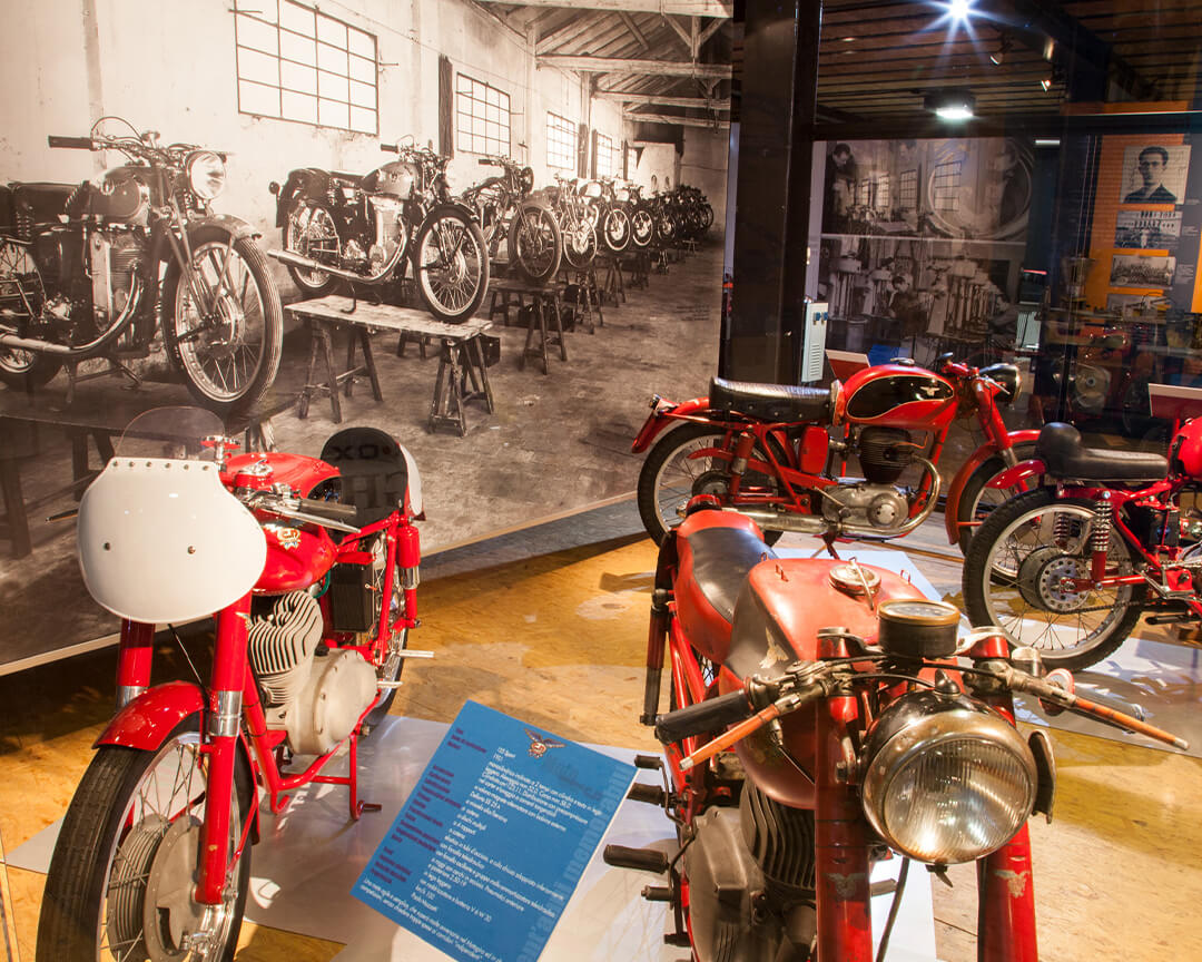 red vintage bikes with technical description and in the background an old photo of the black and white bikes