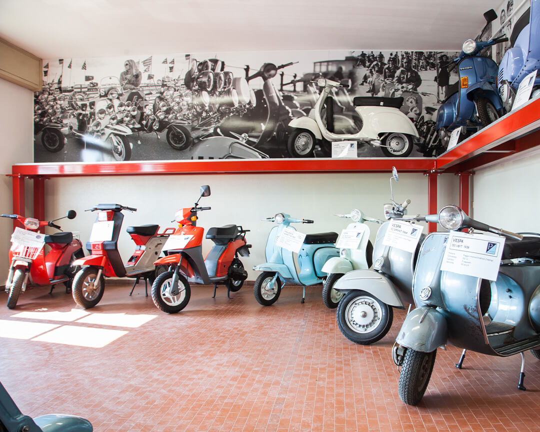 An array of vintage Vespas and mopeds inside the motorcycle museum in scortichino