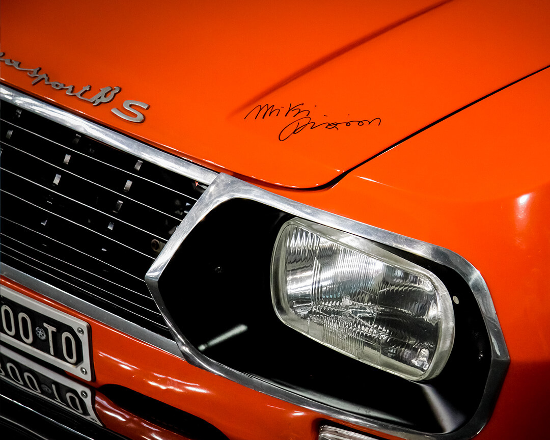 Orange-coloured Sport S classic car with Miki Biason's signature