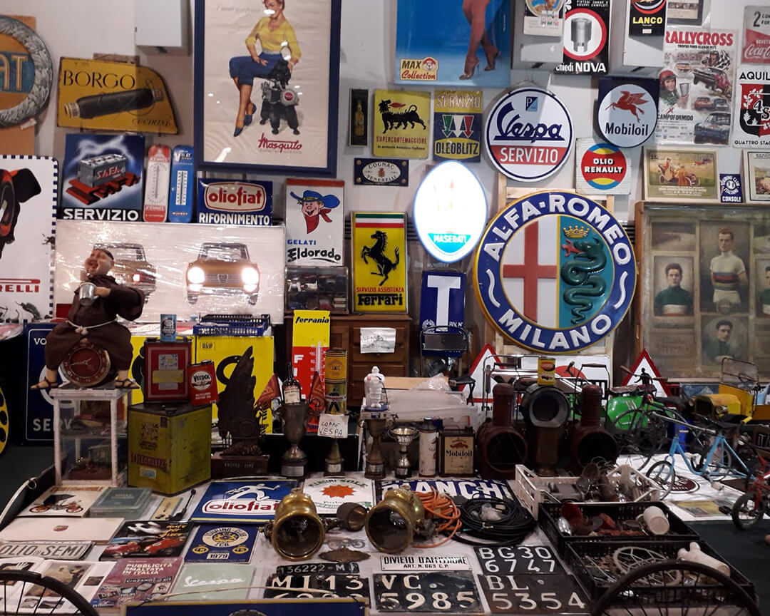 collection of gadgets and nameplates of classic car brands such as alfa romeo, ferrari, vespa