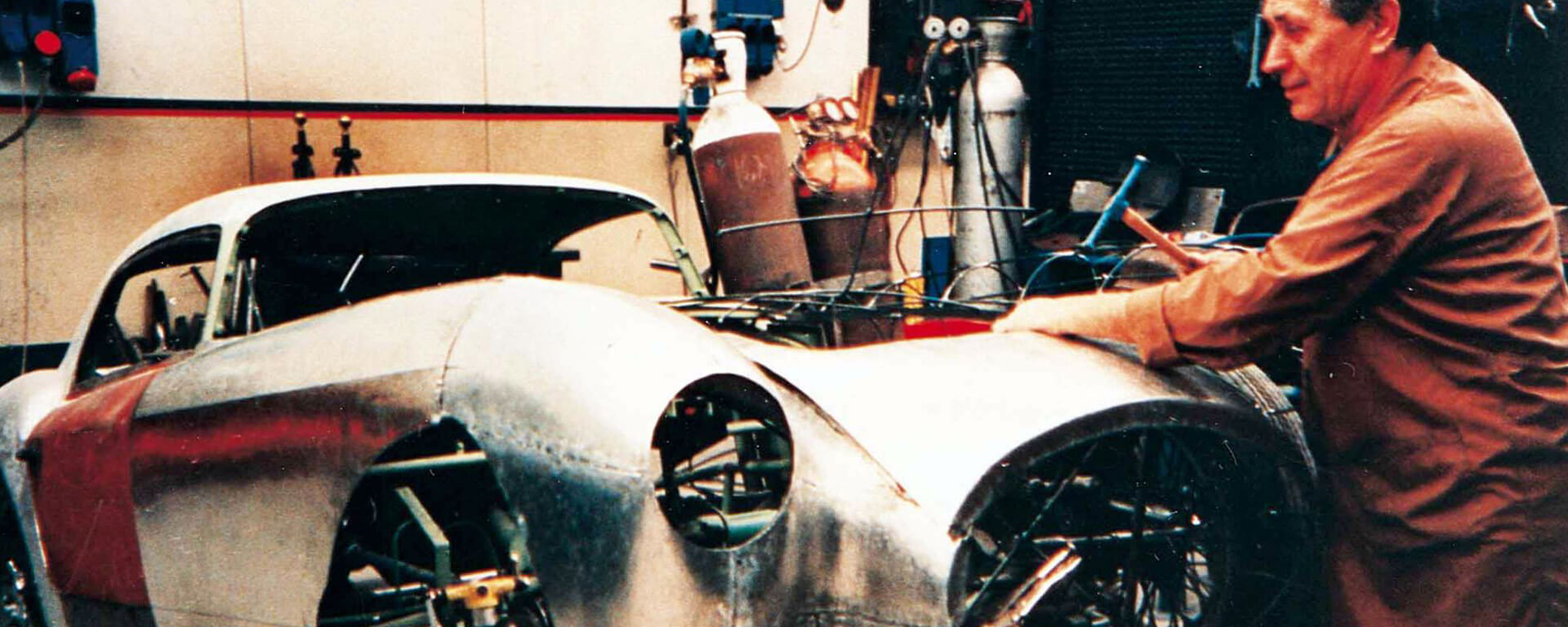 foto vintage di meccanico che sistema un'auto d'epoca nella sua carrozzeria