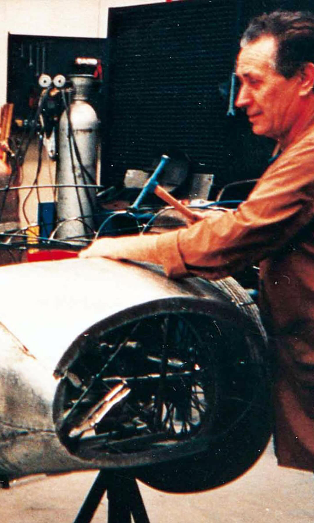 foto vintage di meccanico che sistema un'auto d'epoca nella sua carrozzeria
