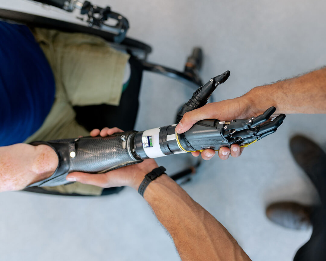 due uomini si stringono la mano 1 dei due ha una protesi meccanica