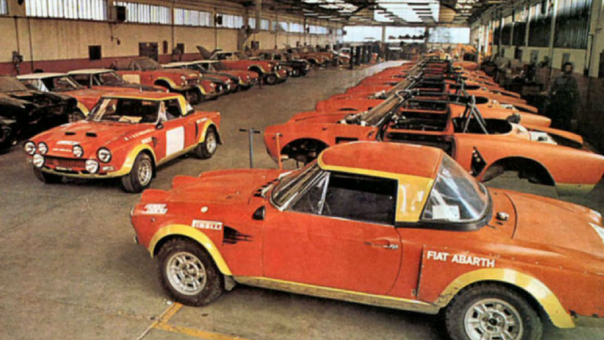 Row of vintage red Fiat Abarth cars parked in a garage