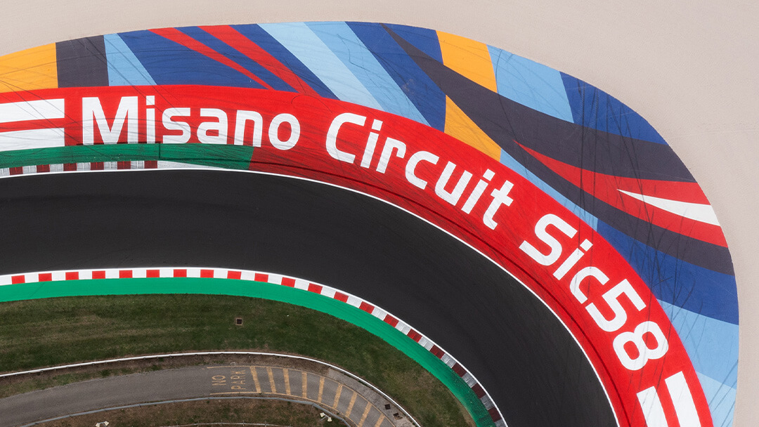 vista dall'alto su una curva del circuito di Misano con la scritta Misano Circuit SIC58