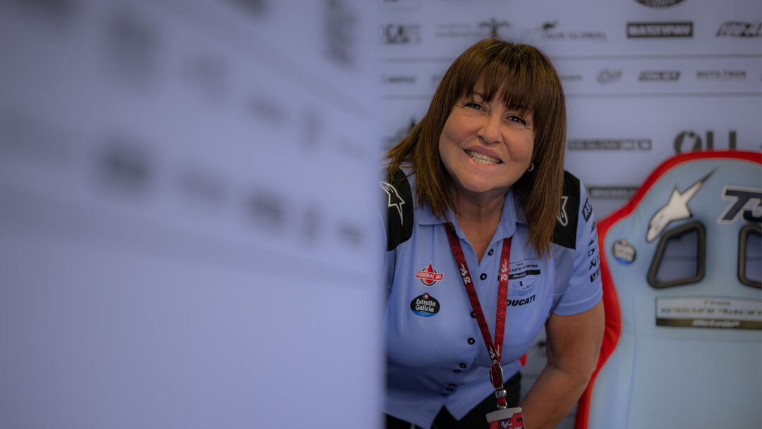 Nadia Padovani, driving the Gresini Racing MotoGP team, who inside the Gresini Racing pit smiles at the snap of a photo.