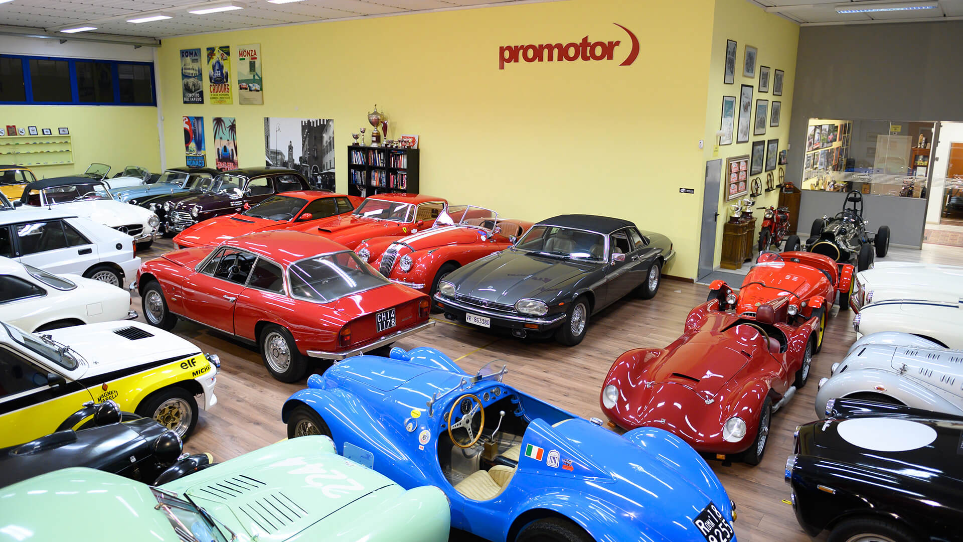 Inside a Promotor exhibition hall, several classic cars are seen parked next to each other.