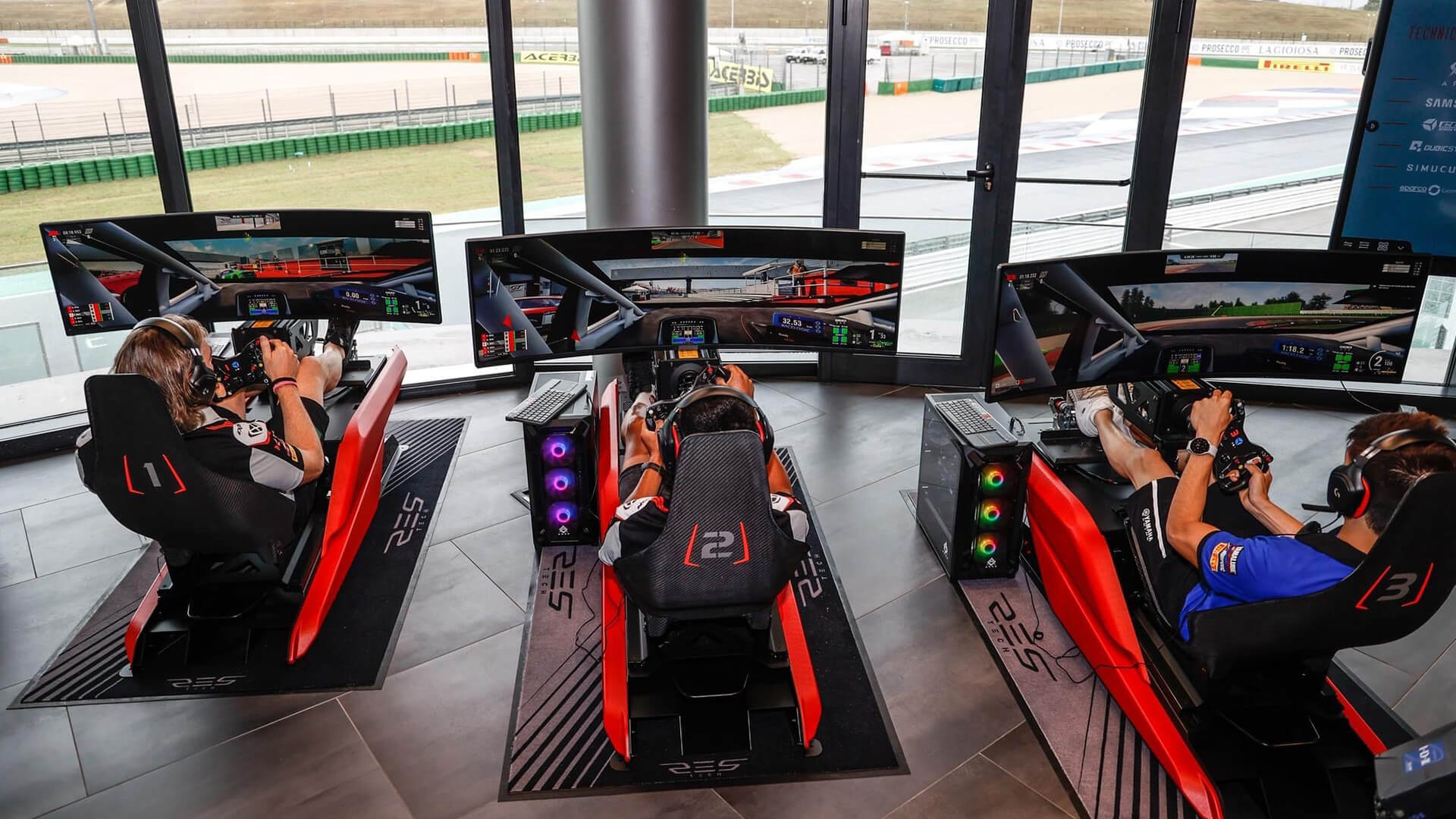 Professional drivers training on driving simulators with glazed view of the circuit of Misano