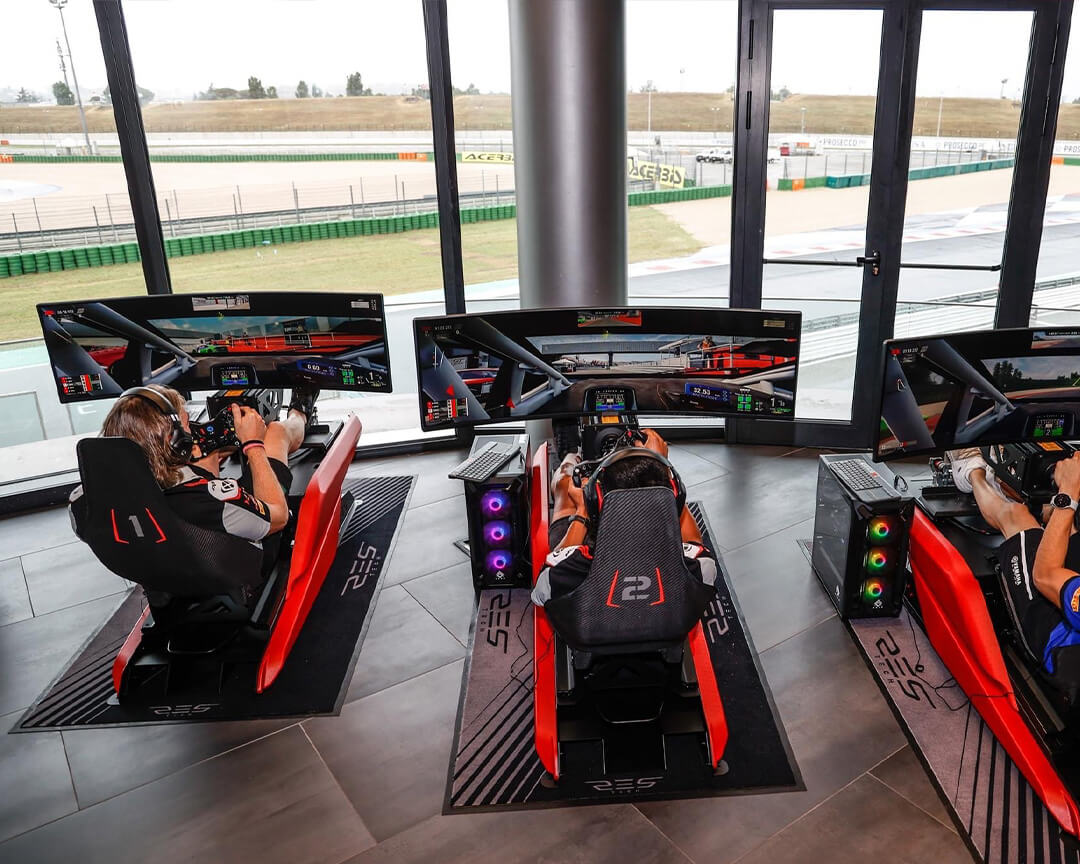 Professional drivers training on driving simulators with glazed view of the circuit of Misano