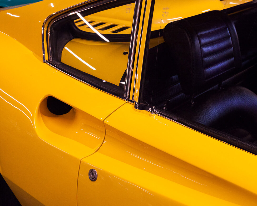 Detail of the window and air intake of a vintage car in yellow coloration within the Ruote da Sogno collection