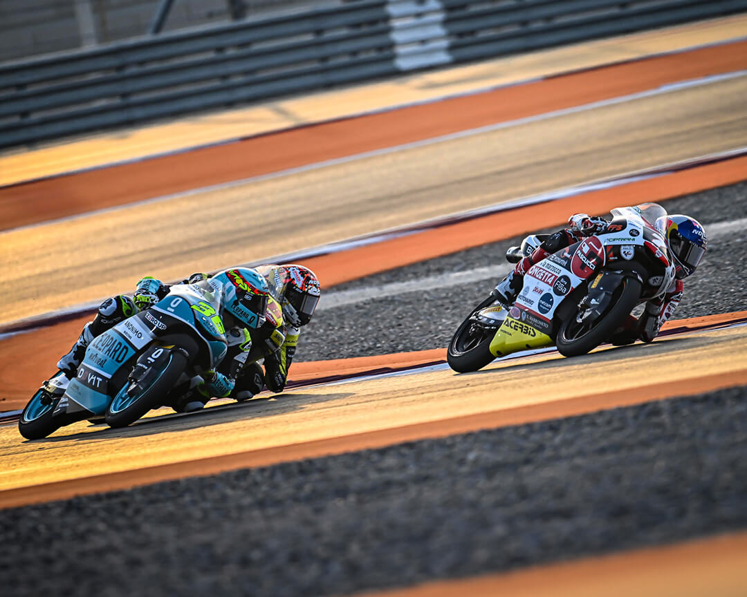 tre piloti di moto che curvano sfiorando l'asfalto del circuito