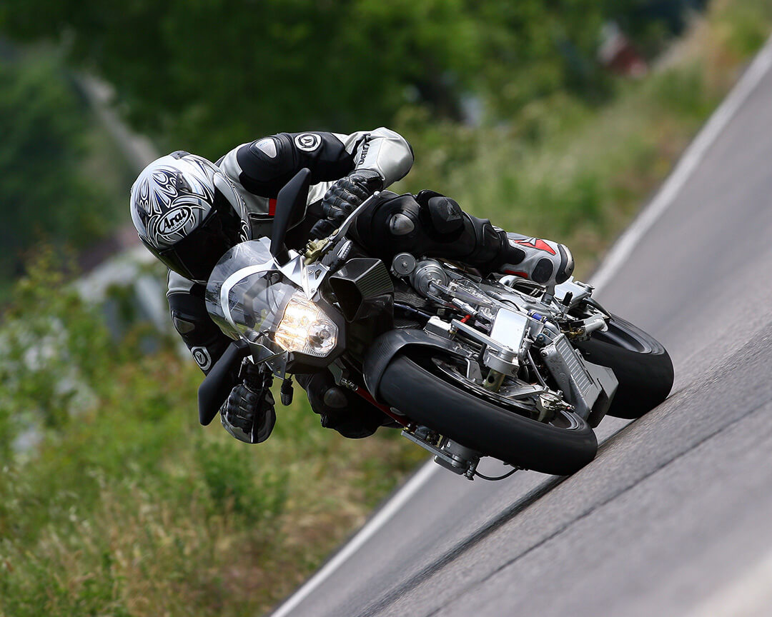 motociclista che corre su strada asfaltata con moto Vyrus