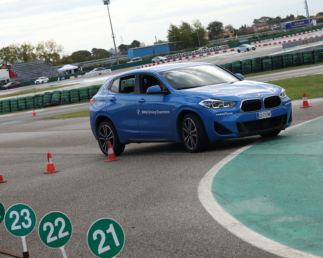 BMW X1 facing a sharp turn during a GuidarePilotare course, inside a track