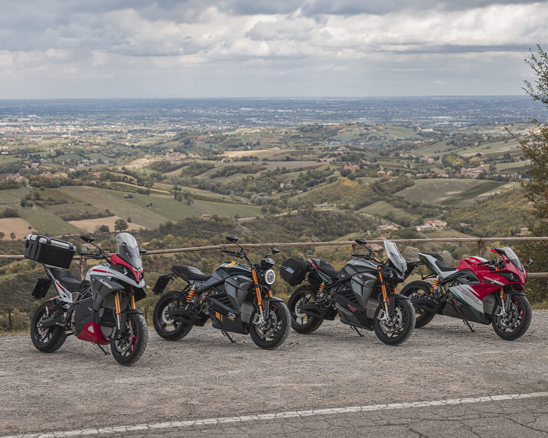 I vari modelli energica motor parcheggiati uno affianco all'altro in una area di sosta di una strada sulle colline italiane