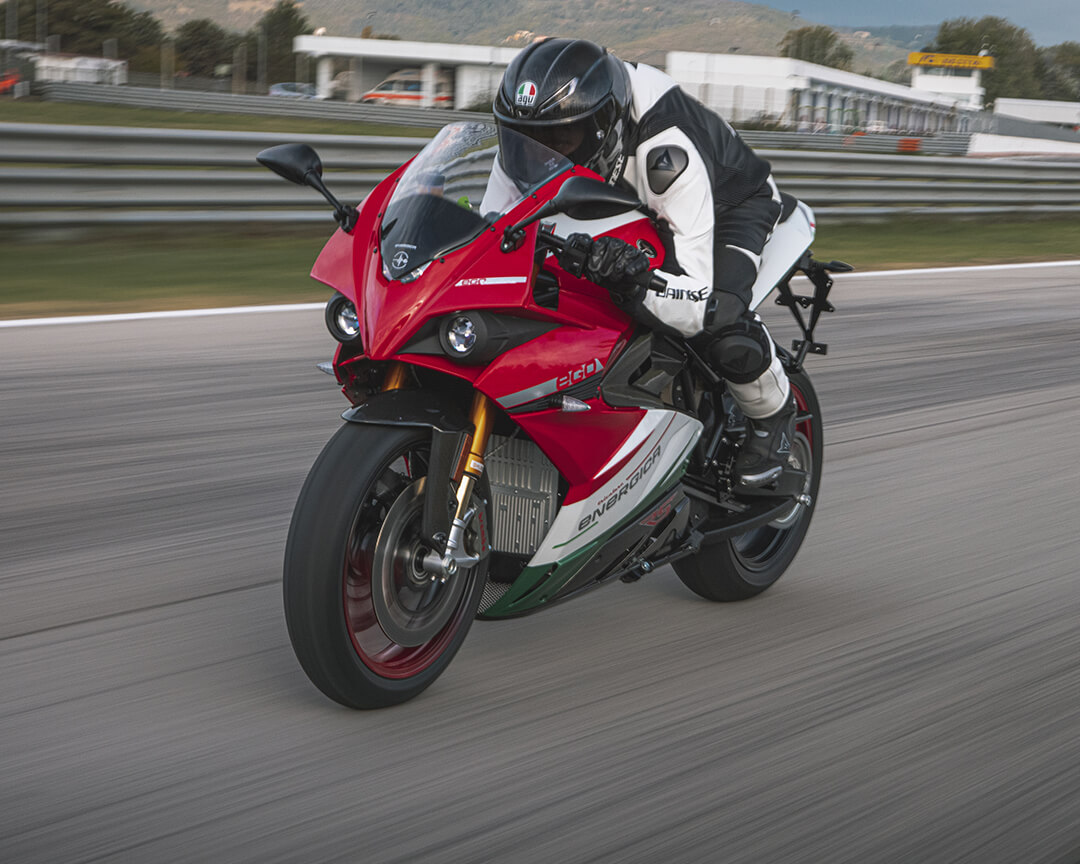 Collaudatore Energica motor che affronta un rettilineo di un circuito in sella ad una ego in colorazione rossa bianca e nera
