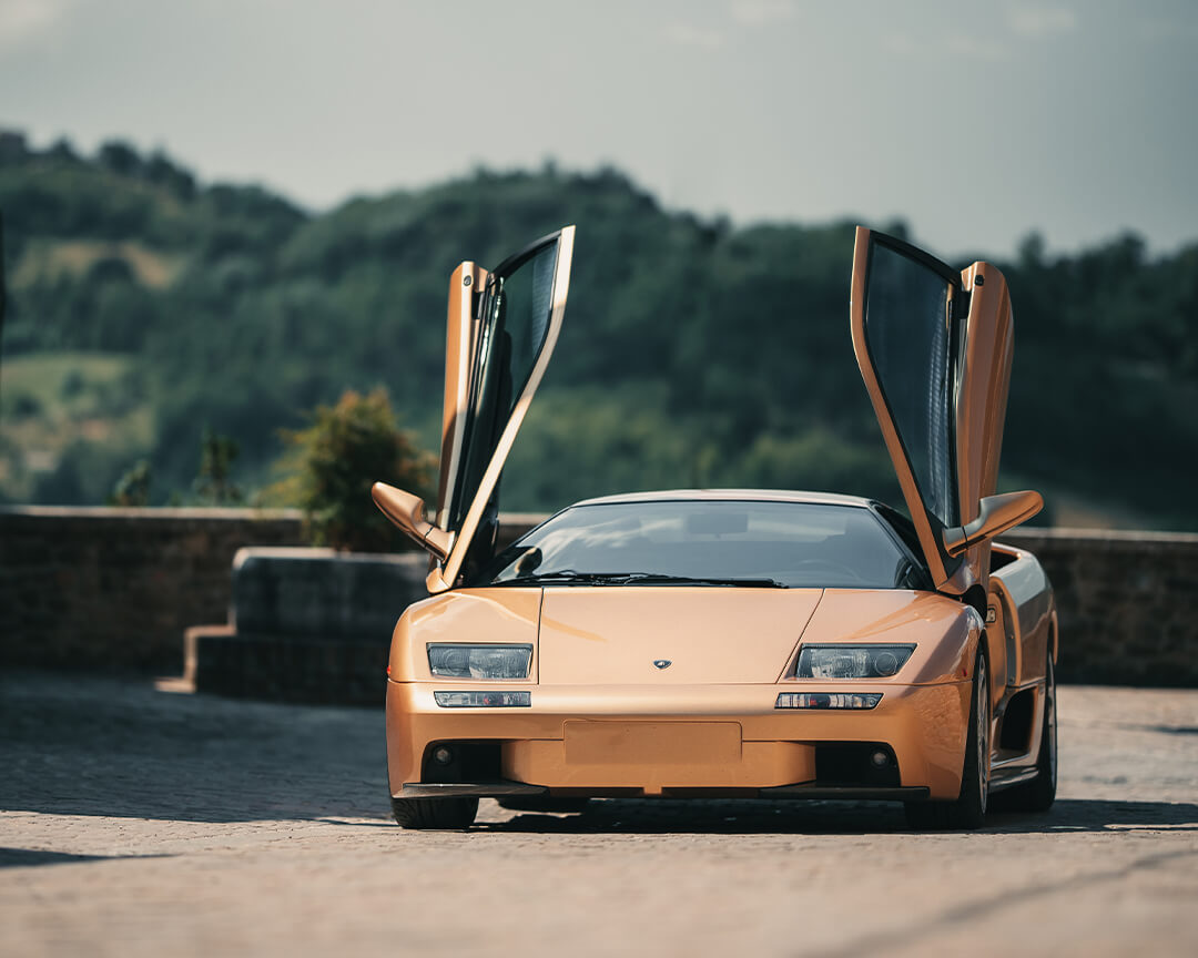 super car Lamborghini d'epoca color champagne con le portiere apribili verso l'alto