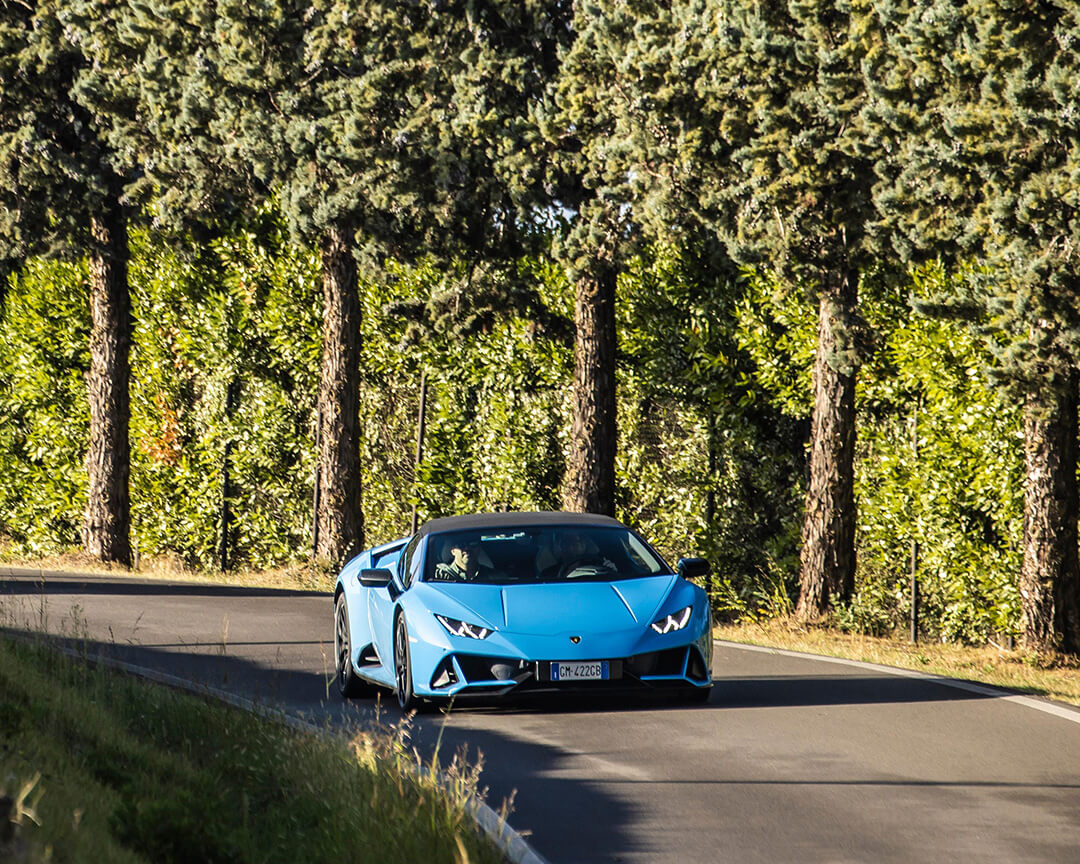 Lamborghini Uracan azzurra su asfalto e sullo sfondo alberi