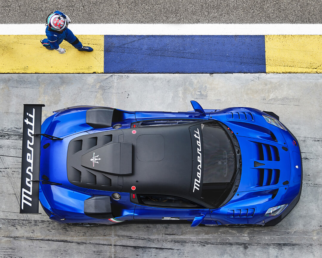 vista zenitale su Maserati racing blu con pilota in avvicinamento e cordolo giallo blu