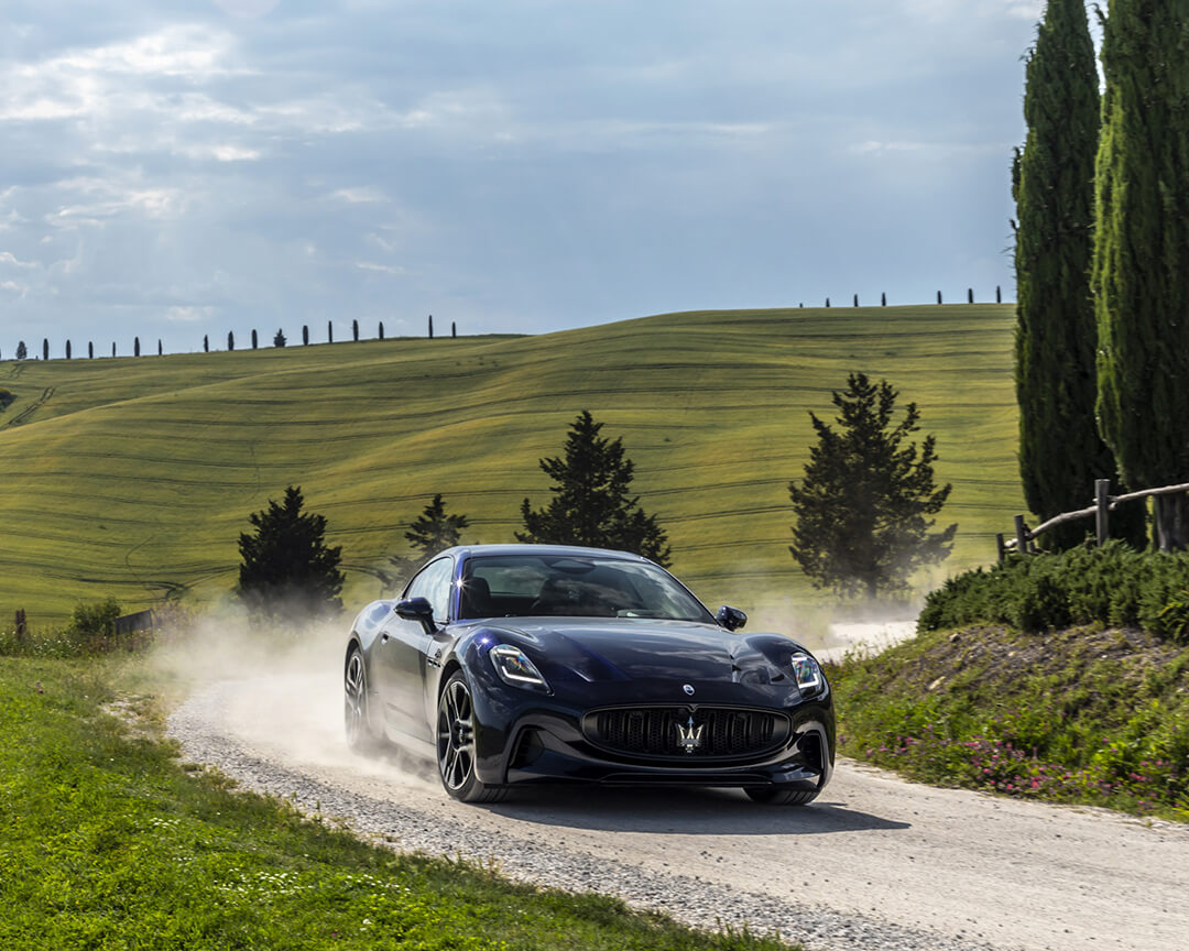 berlina maserati su strada sterrata della campagna toscana