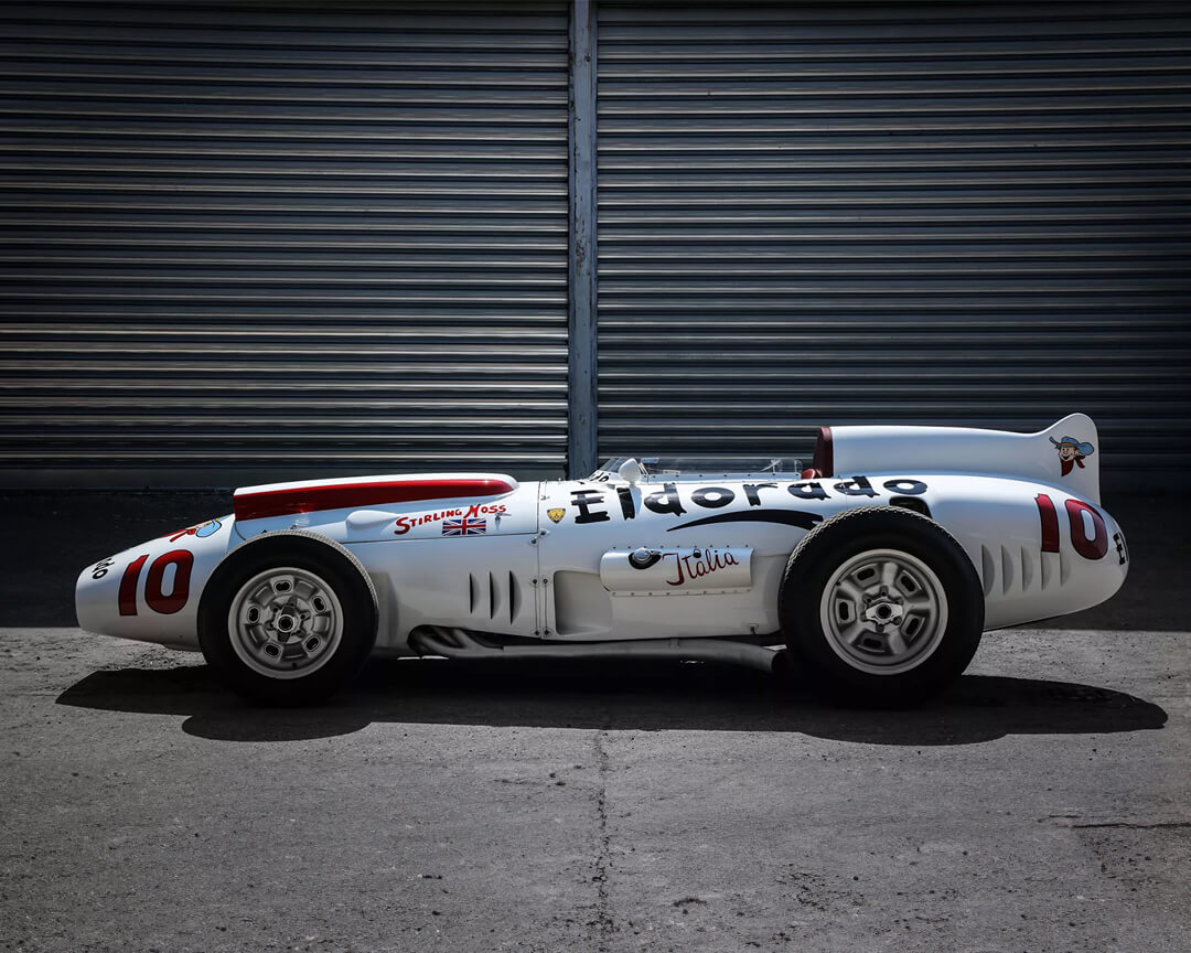 laterale di una Maserati Eldorado d'epoca con scritta sulla fiancata davanti a box di un paddock
